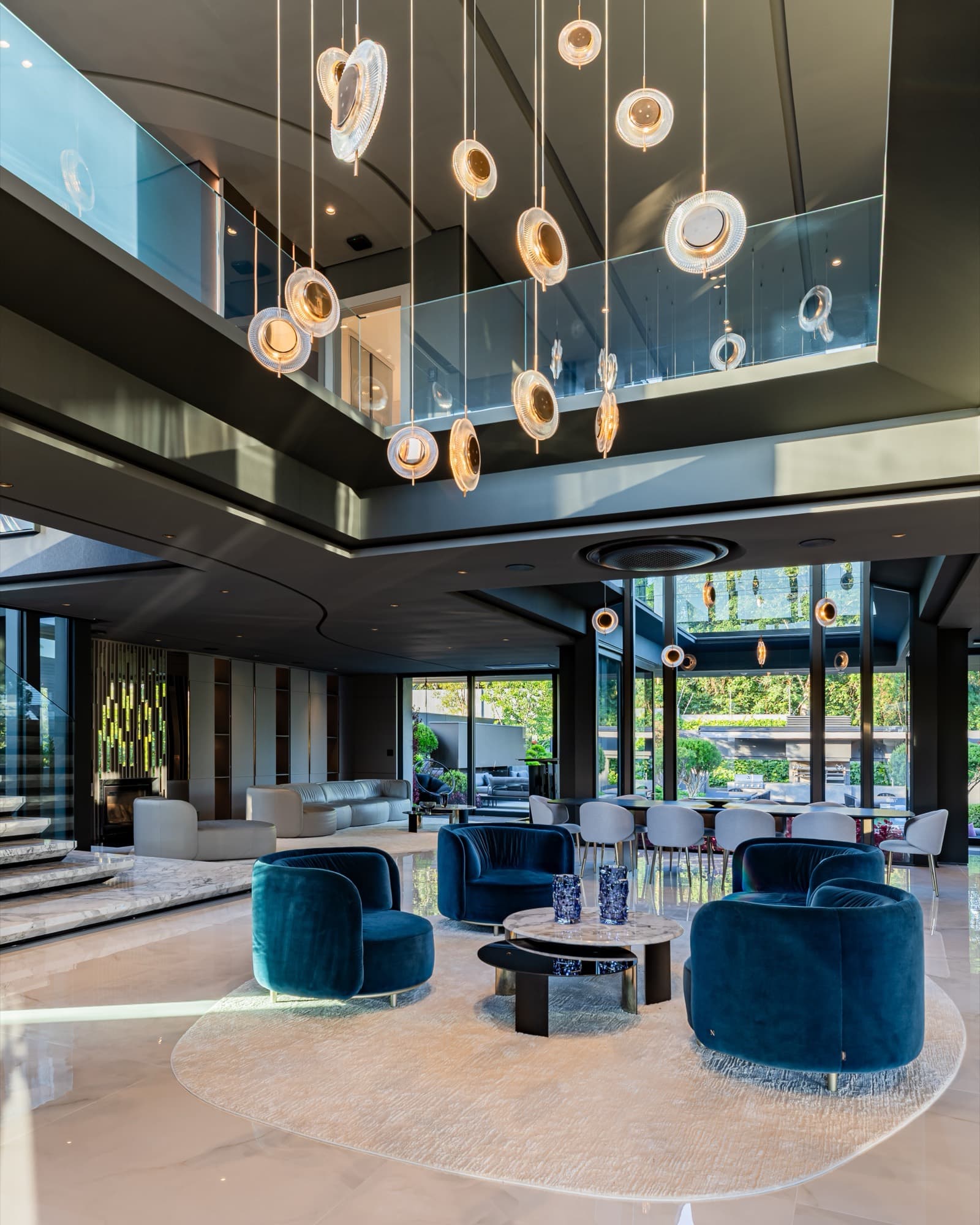 Sala de estar com pé-direito duplo, envidraçamento e luminárias pendentes